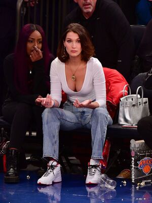 Bella Hadid in jeans and tight blouse shows cleavage
